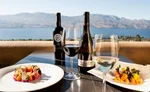 Closeup of a nice meal with wine with the Okanagan Lake in the background.