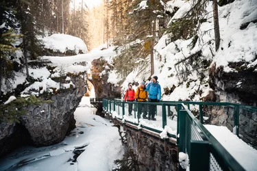 Small group standing on a viewing platform in the icy Johnston Canyon