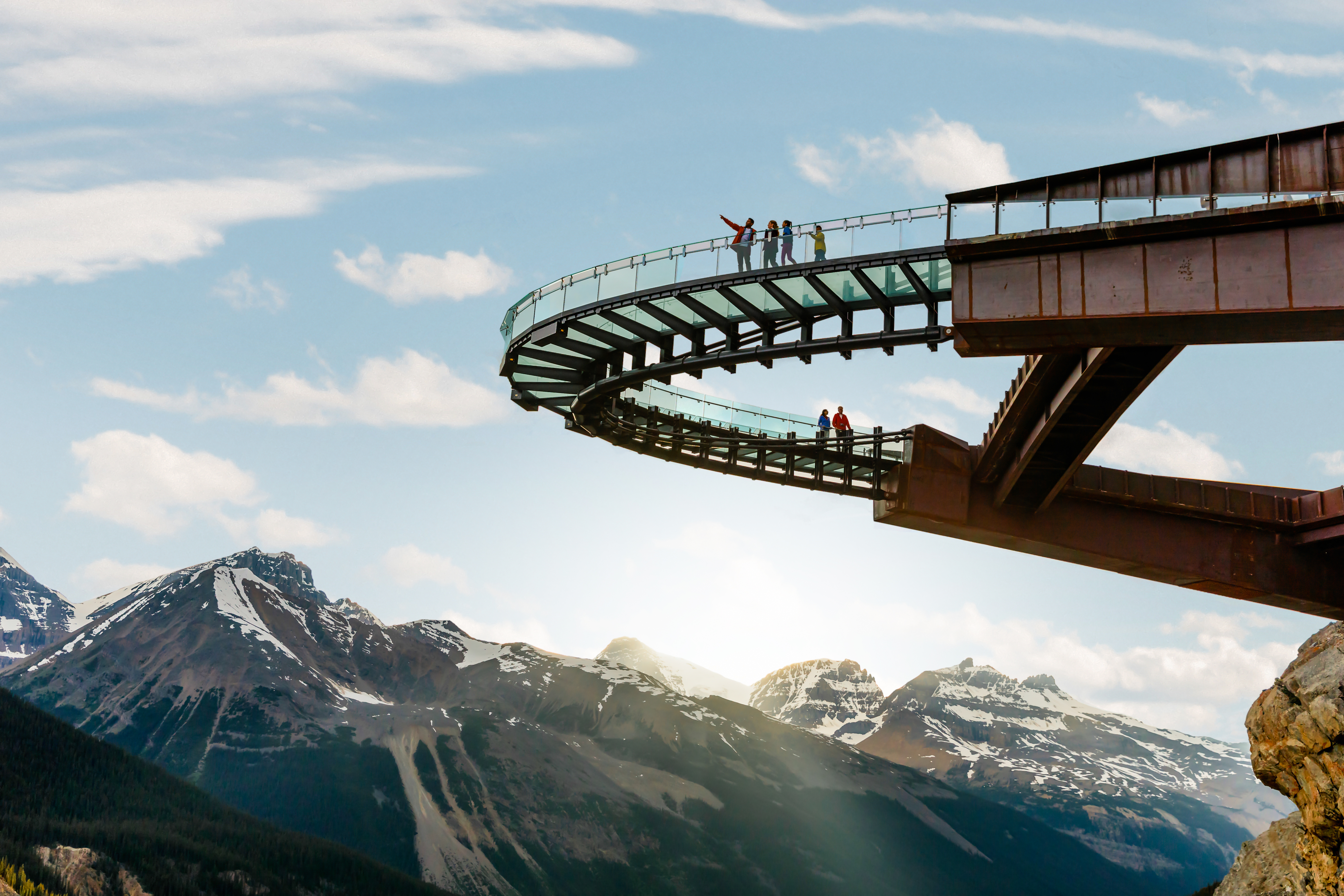 People on a glass-floored walkway looking out at the mountains on the Icefields Parkway