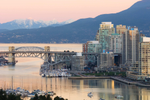 View of Burrard Street Bridge, skyscrapers and snowy mountains in Vancouver
