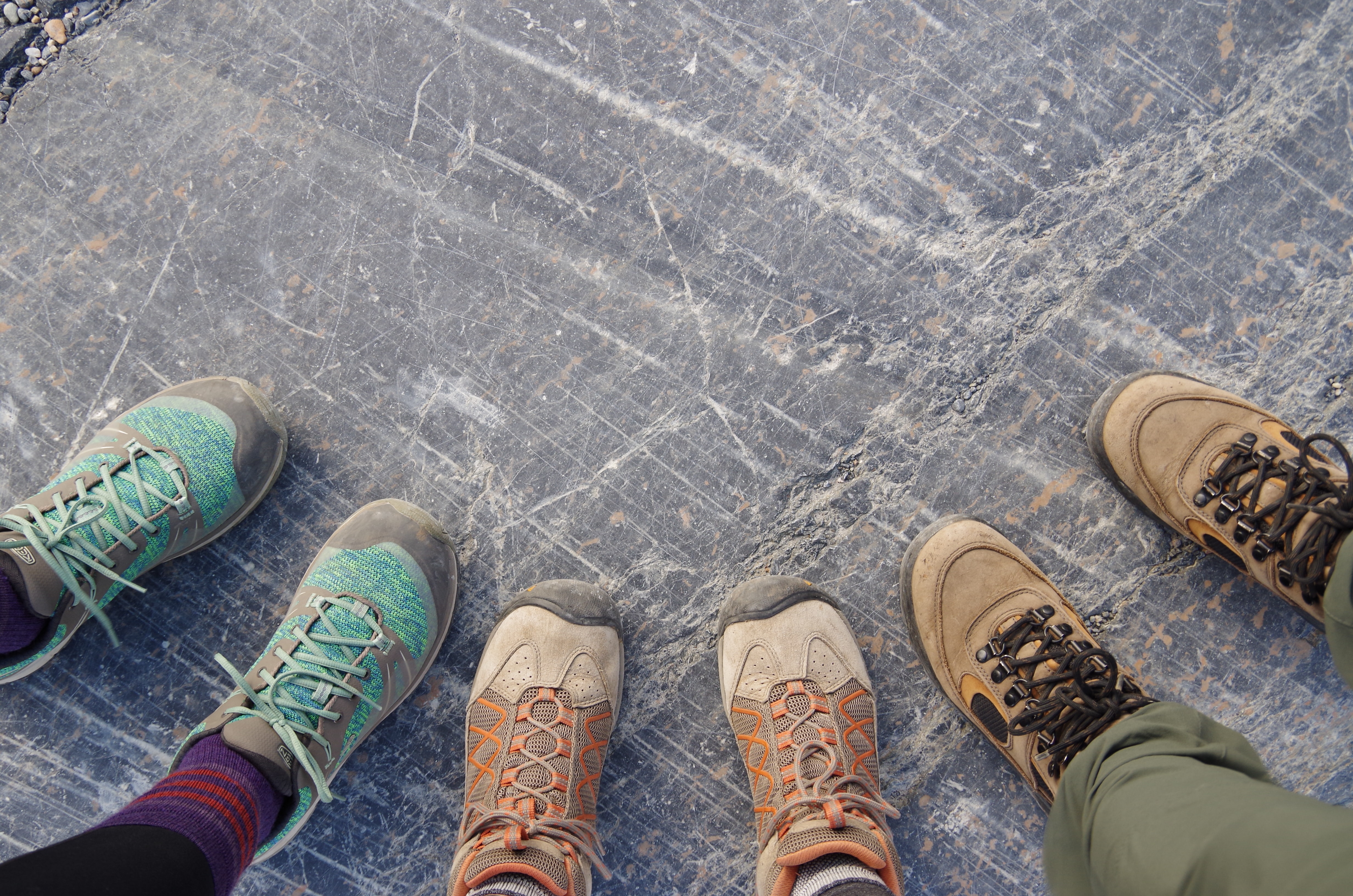 Three people wearing hiking shoes in Athabasca Glacier