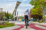 Person riding a BMX bike along the colourful pathways in the Montreal Olympic Park
