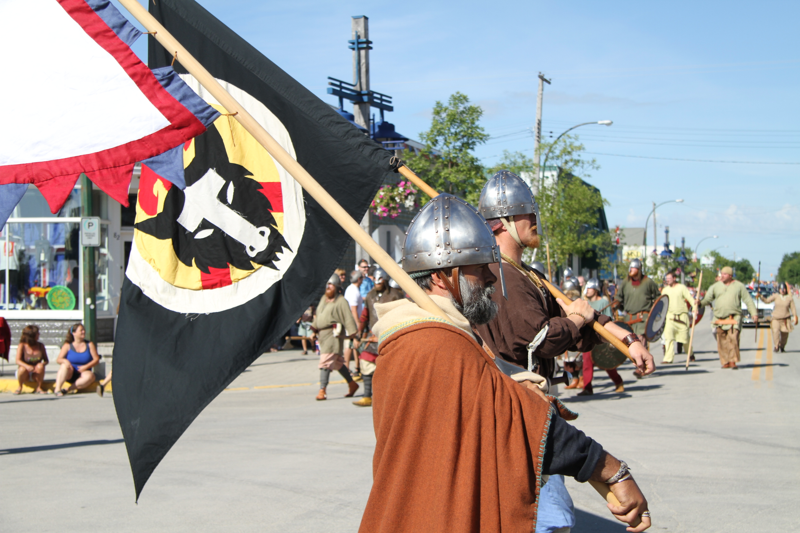 People in viking costumes walking down a street as part of the Icelandic Festival in Gimli
