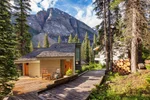 View of cabins surrounded by forest and mountains at Moraine Lake Lodge 
