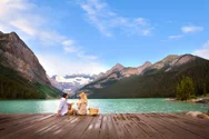 A couple enjoys a picnic on the dock over Lake Louise