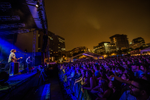 Crowd of people watching a musician on the Halifax Jazz Festival main stage at night 