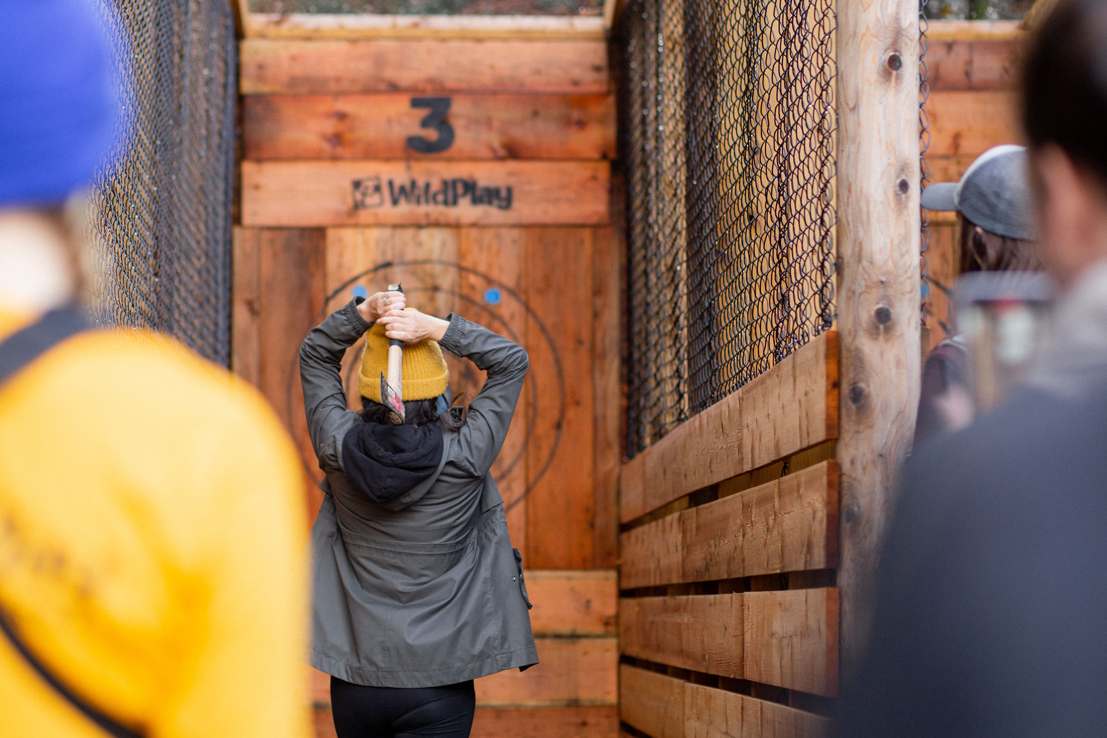 View of two people watching a friend throw an axe at a Wildplay Park