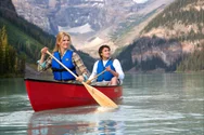 A couple is pictured, canoeing on the clam waters of Lake Louise.