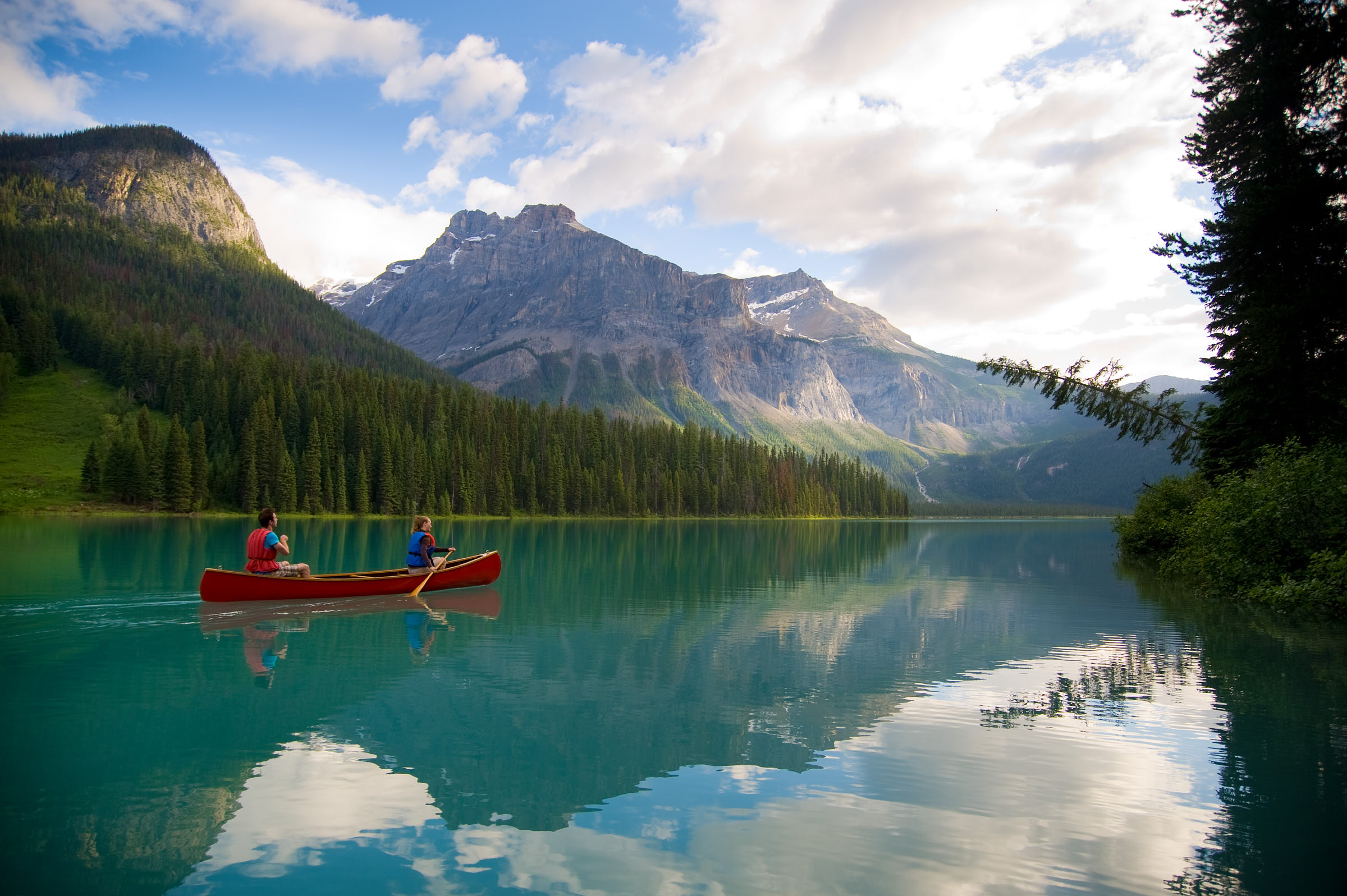 Couple canoeing on Emerald Lake with views of the mountains in Yoho National Park near Field