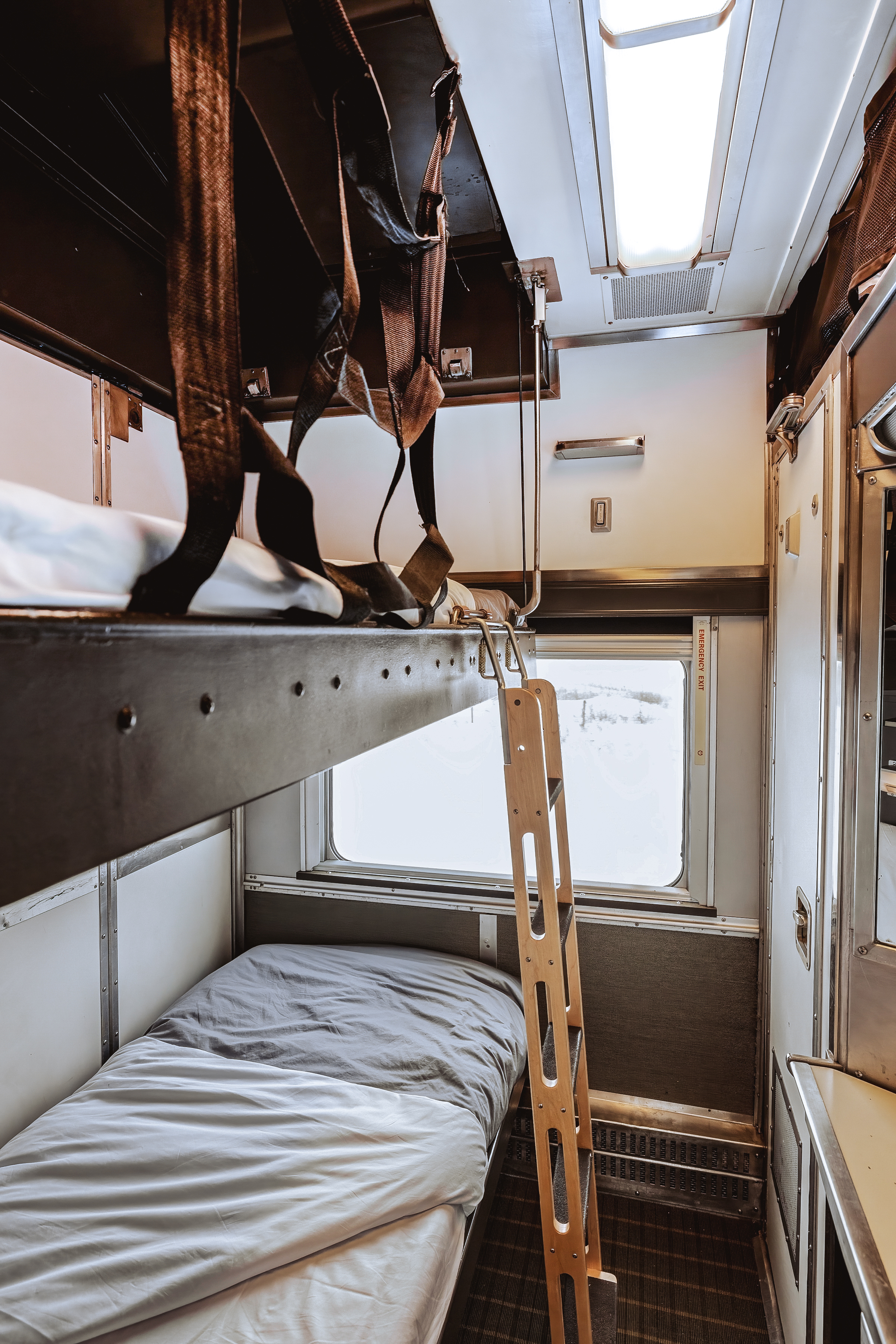 Ladder, upper and lower beds in Sleeper Plus class cabin with large window onboard VIA Rail's train, The Canadian