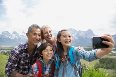 Family taking cell phone picture on rural hillside