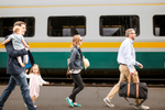 A family walk along the platform next to a VIA Rail train