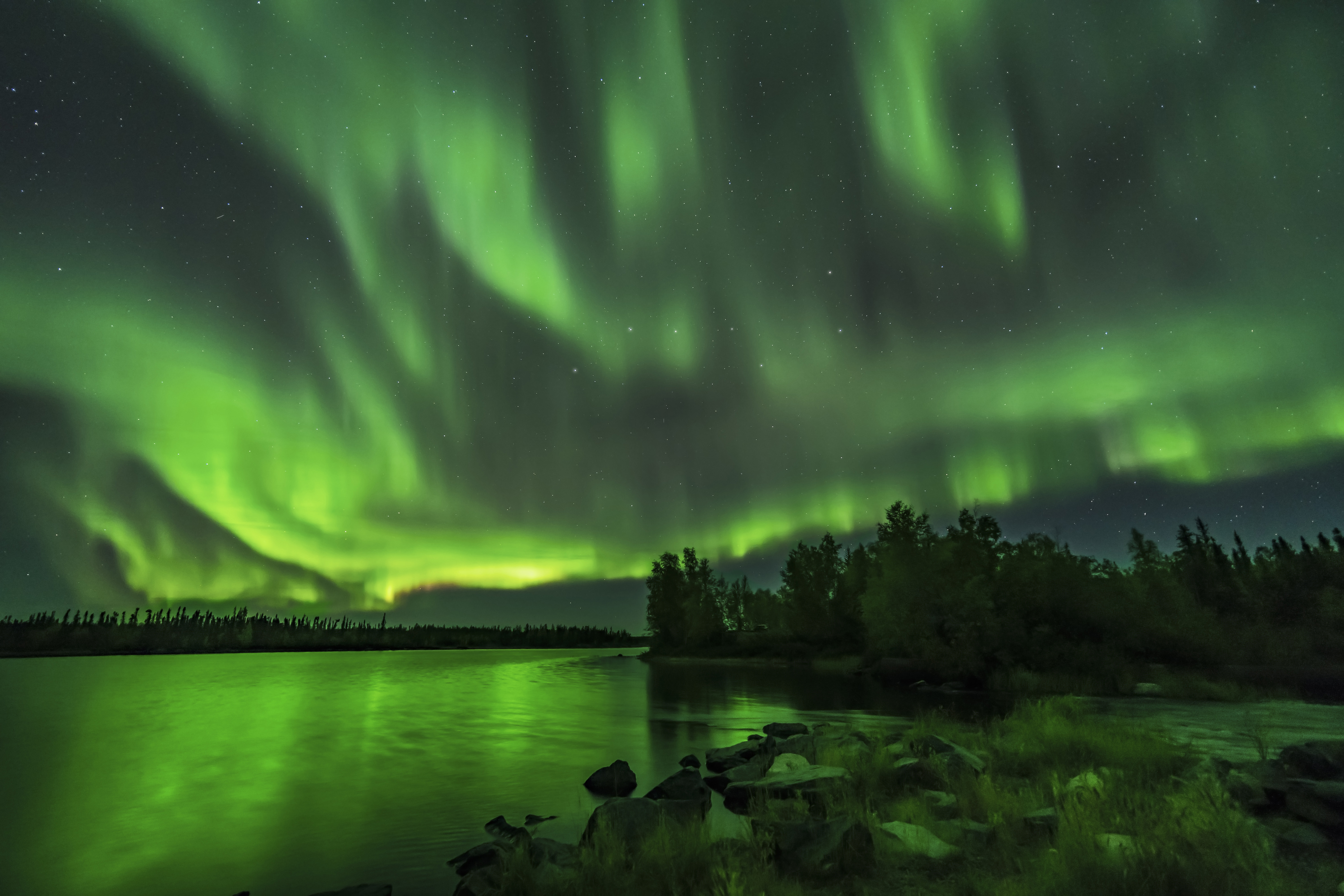Display of northern lights above Tibbit Lake located on the Ingraham Trail in Yellowknife, Northwest Territories of Canada