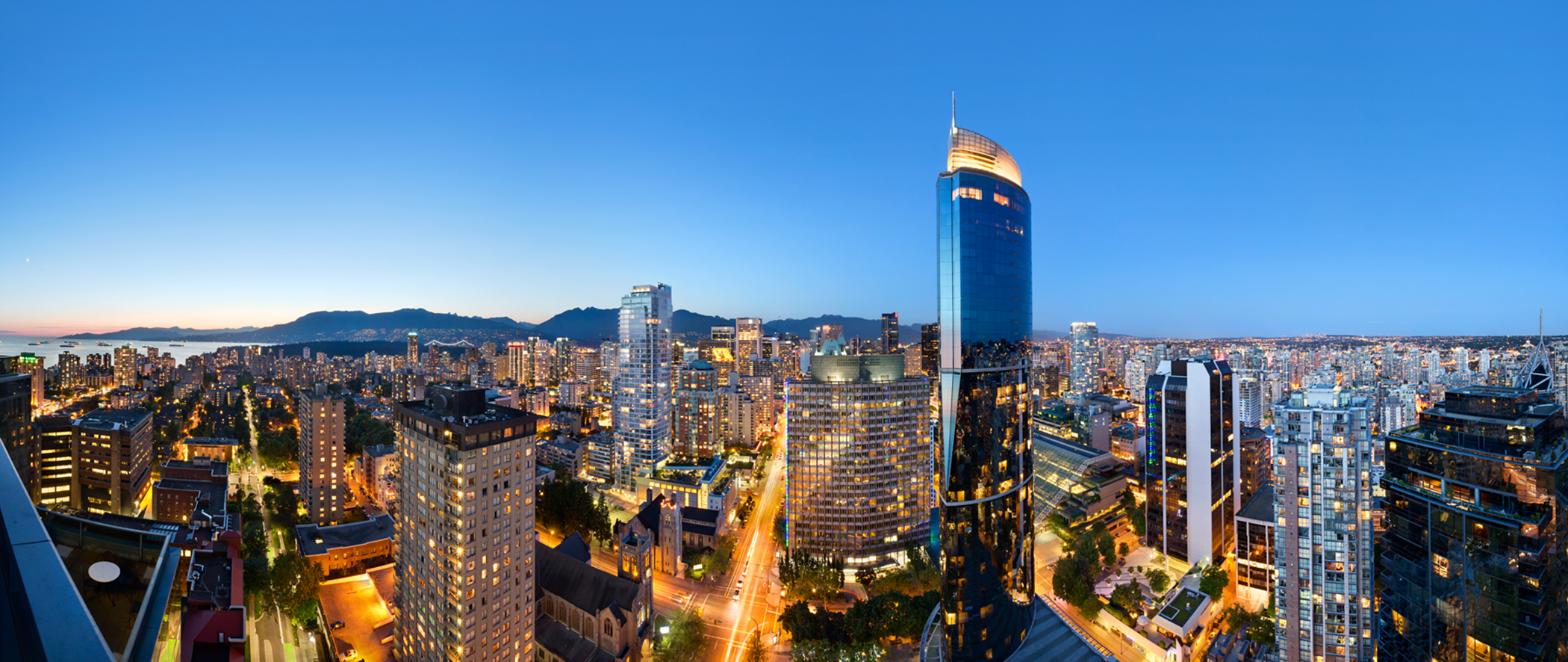 Hotel high-rise in vancouver with mountains in the distance