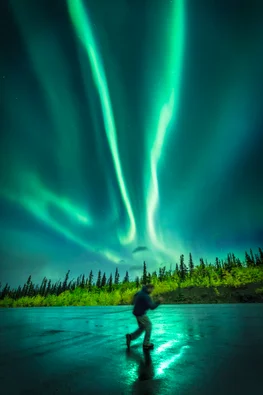 Man running under the northern lights in Kluane National Park, Yukon