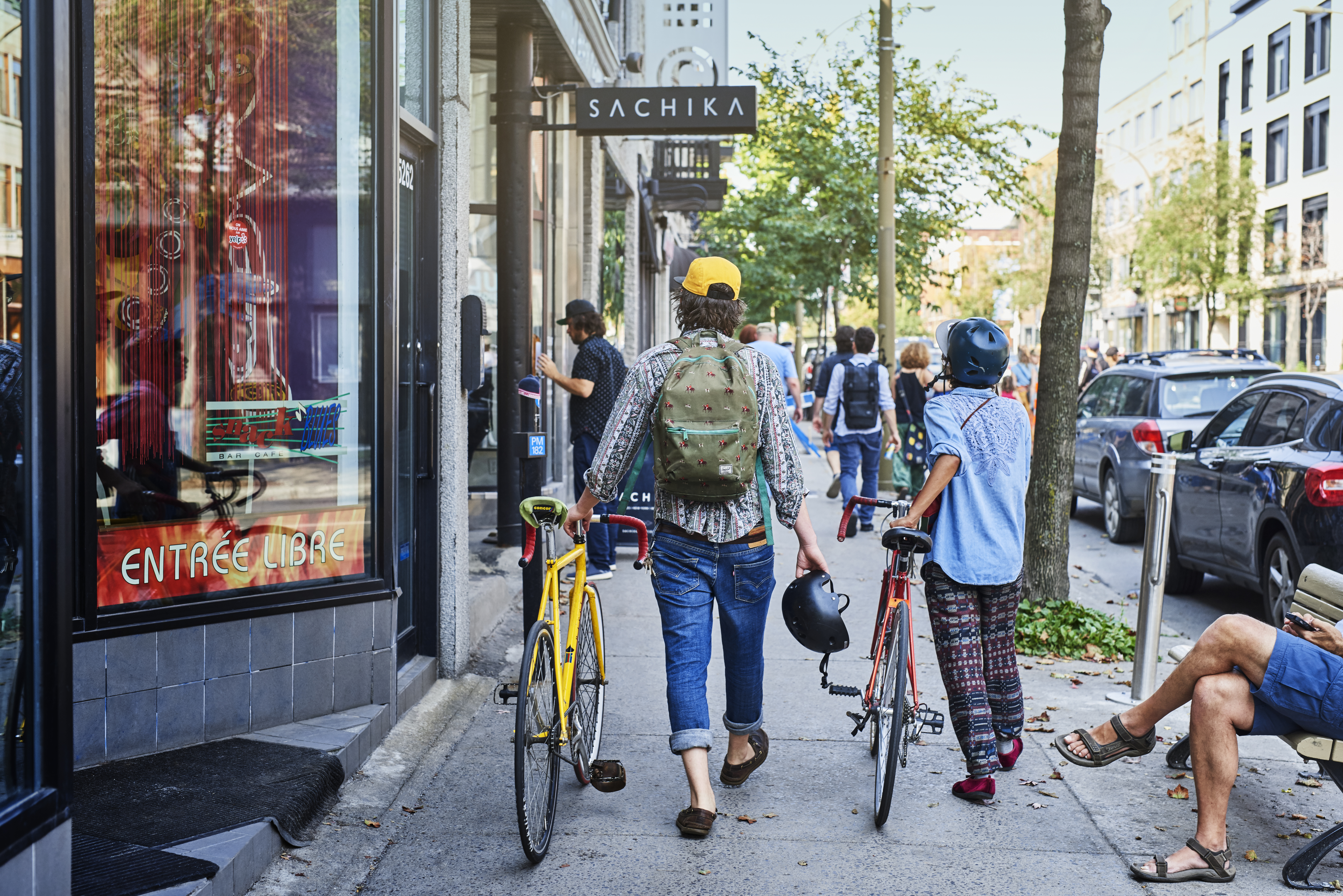People walk with bikes through Montreal's Mile End neighbourhood