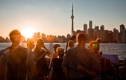 A small group of people watch the sunset over the Toronto Skyline