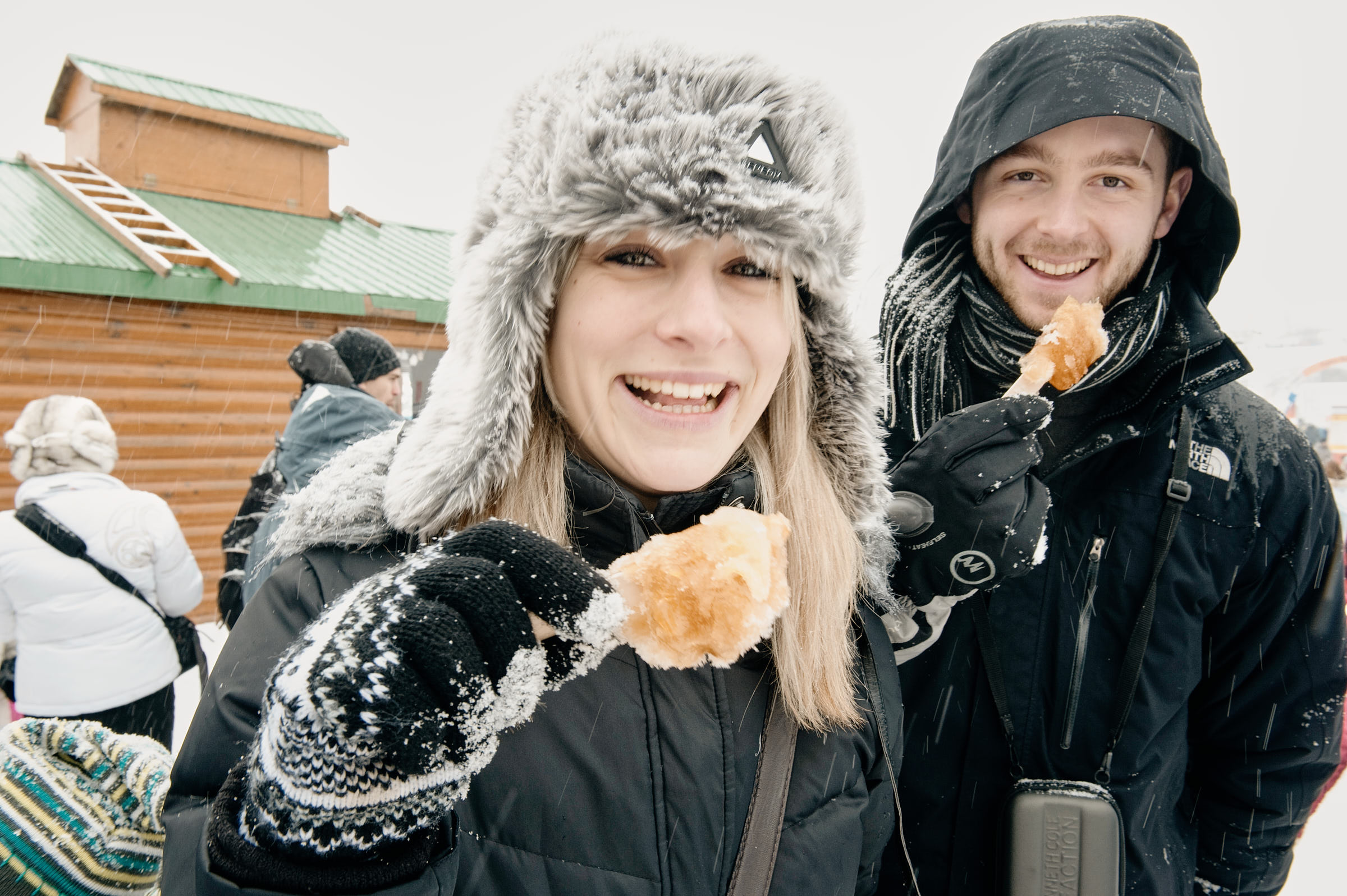 A couple enjoys sugar shack maple taffy candy at Quebec City’s Winter Carnaval