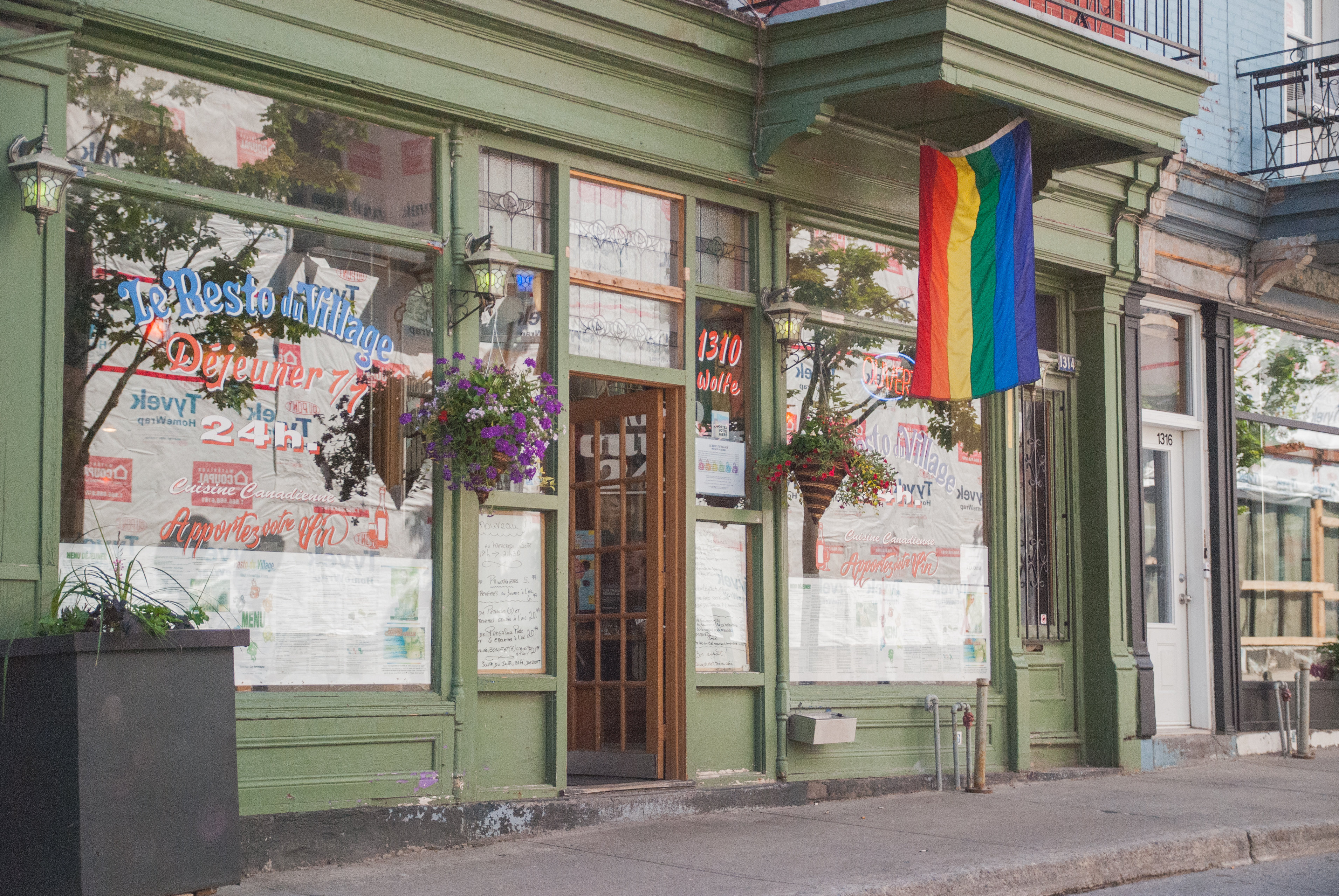 Exterior view of a restaurant in The Village neighbourhood with a pride flag hanging outside