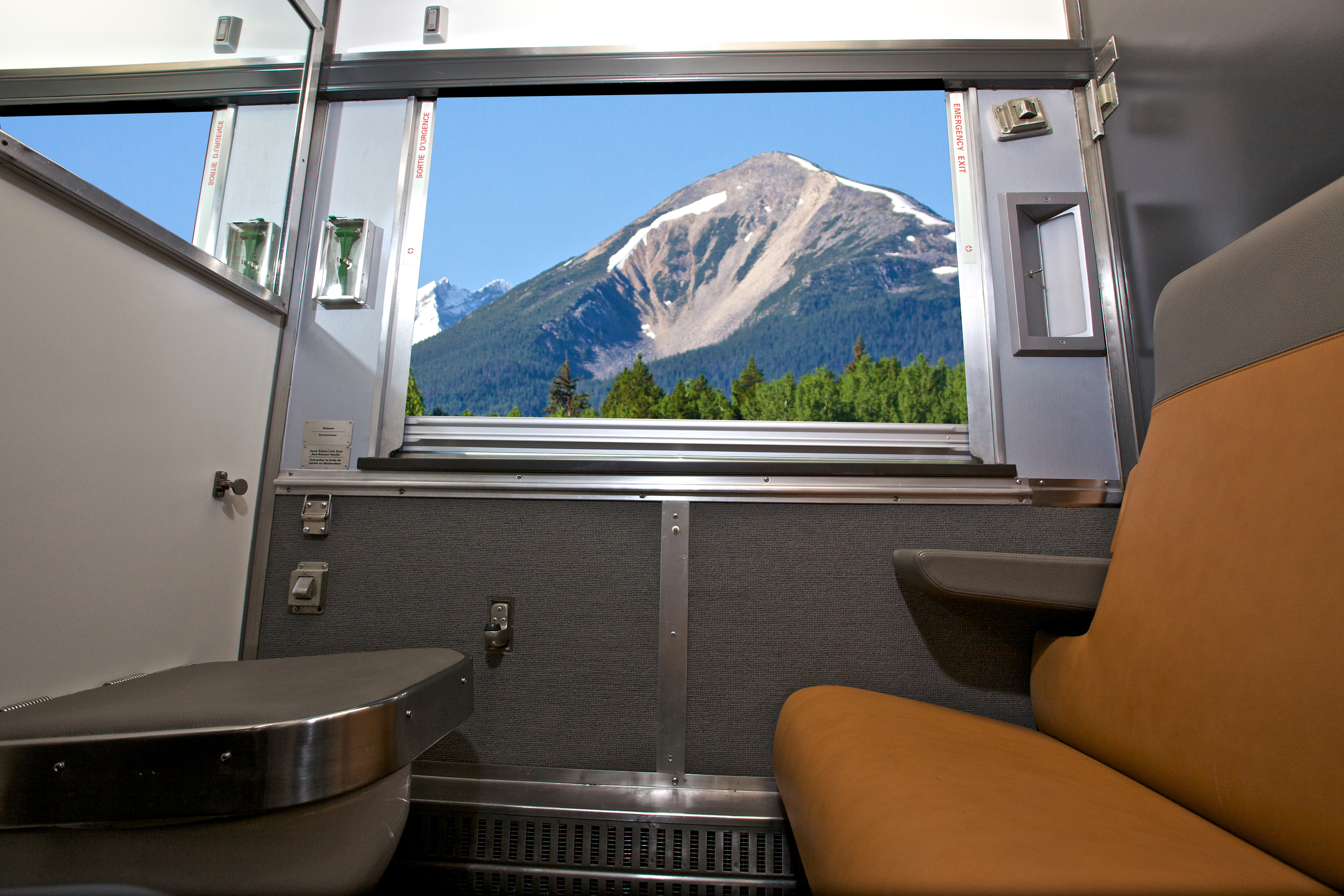 VIA Rail sleeper cabin for one bench seat across from toilet with the window and mountain view.