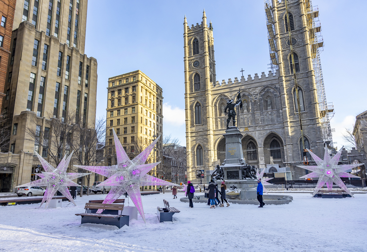 Place d'Armes Square with snow on the ground, star-shaped lights and the Notre-Dame Basilica