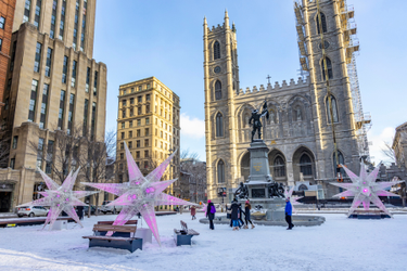 Place d'Armes Square with snow on the ground, star-shaped lights and the Notre-Dame Basilica