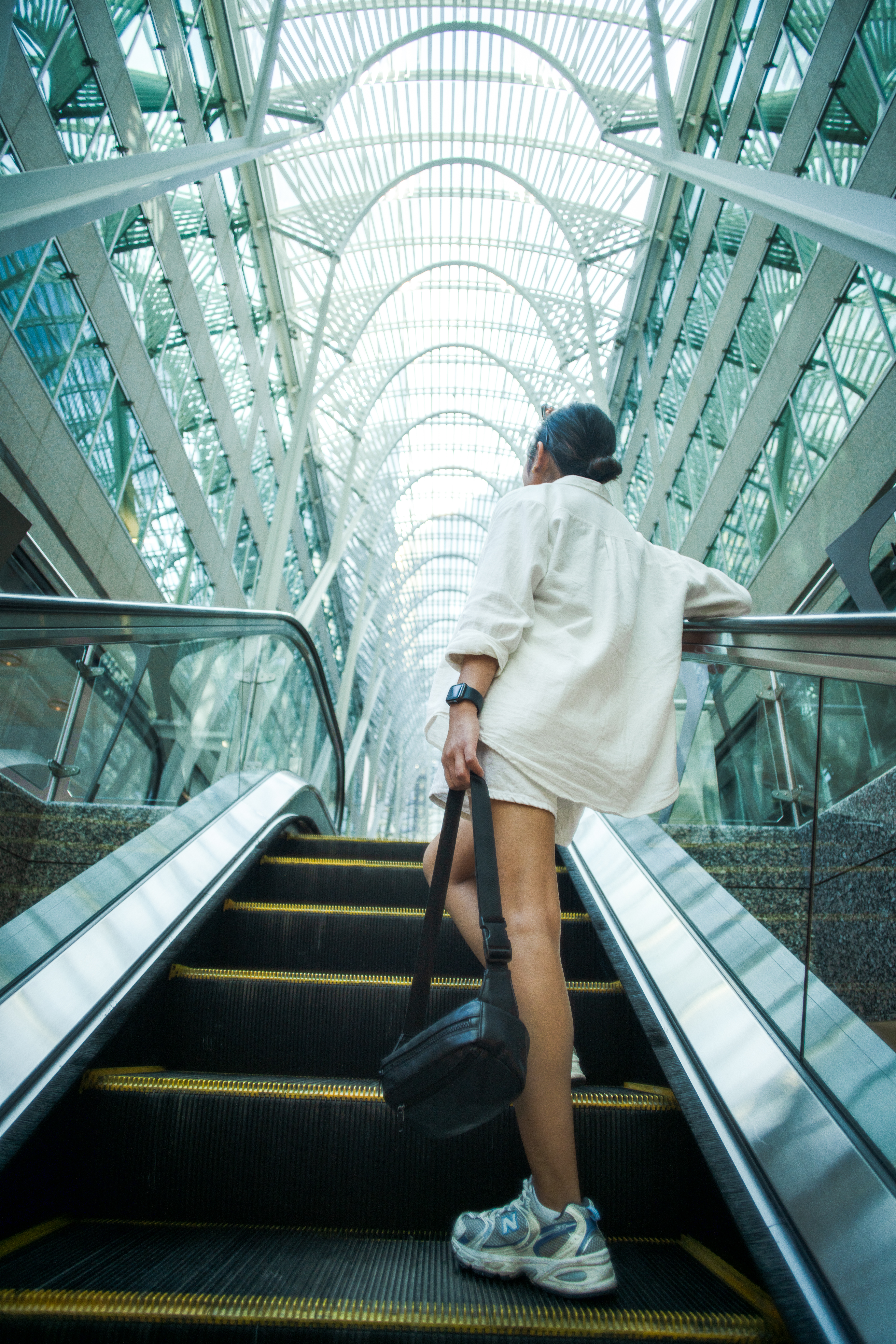 Woman standing on an escalator inside a mall in Toronto