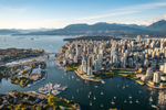 Aerial view of Vancouver city with boats in the water and mountains behind 