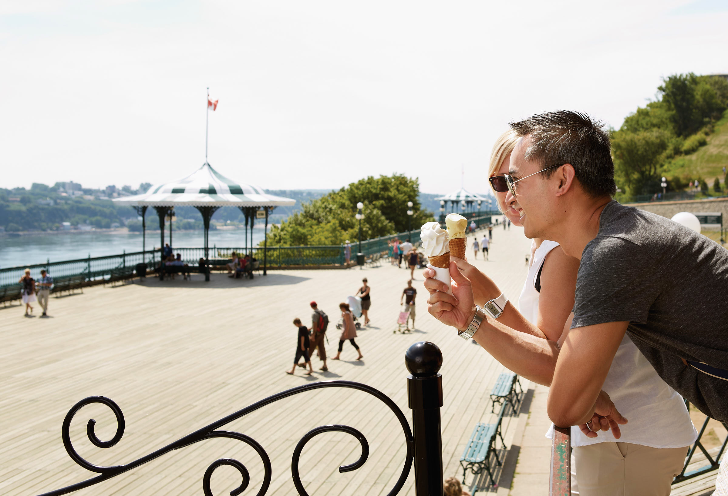 A couple eats ice cream and looks over Quebec City's Dufferin Terrace