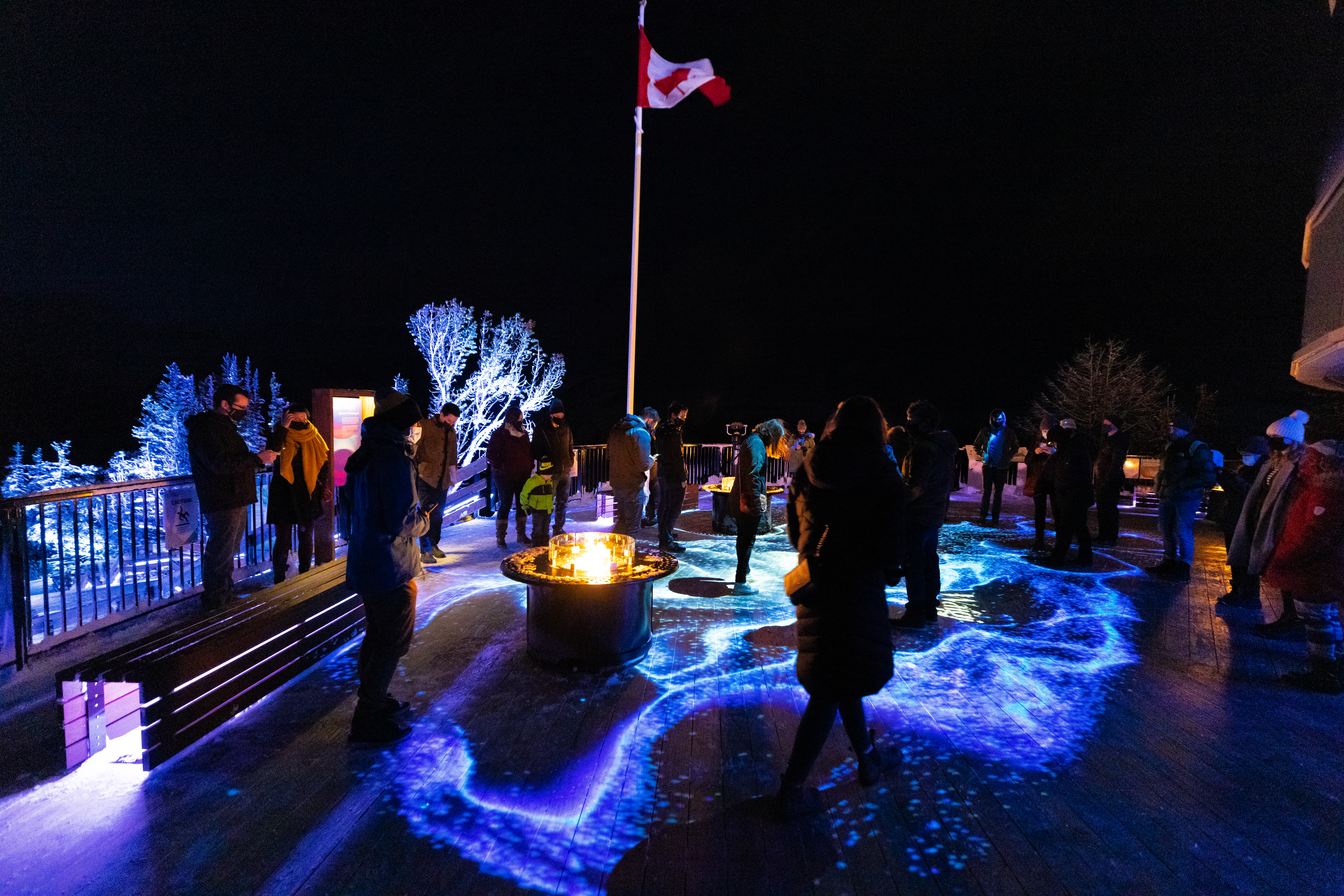 People exploring the Nightrise art installations at Banff Gondola at night