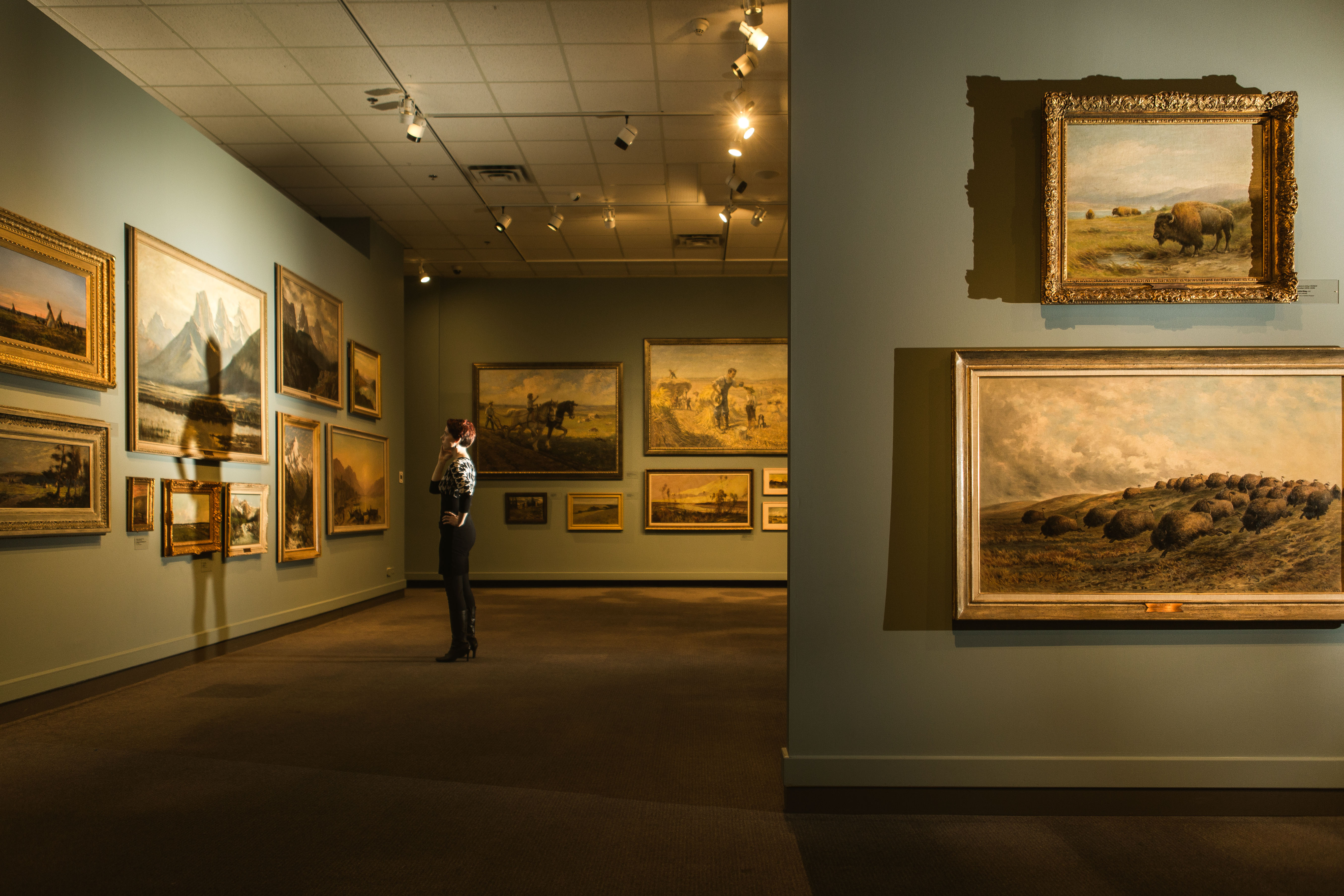 View of framed art on the walls in one of the exhibits at Glenbow Museum