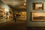 View of framed art on the walls in one of the exhibits at Glenbow Museum