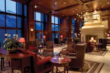 Elegant lobby with armchairs and fireplace and floor-to-ceiling windows at Rimrock Resort
