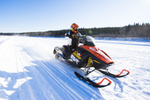 Person on a snowmobile on fresh snow near forest in Northwest Territories, Canada 