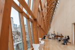 People sitting indoors near large windows in a cafe area of an art gallery 