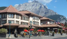 Elk and Avenue Hotel in Banff in the summer with mountains behind
