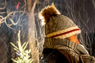 Woman with a toque and scarf standing on a snowy night