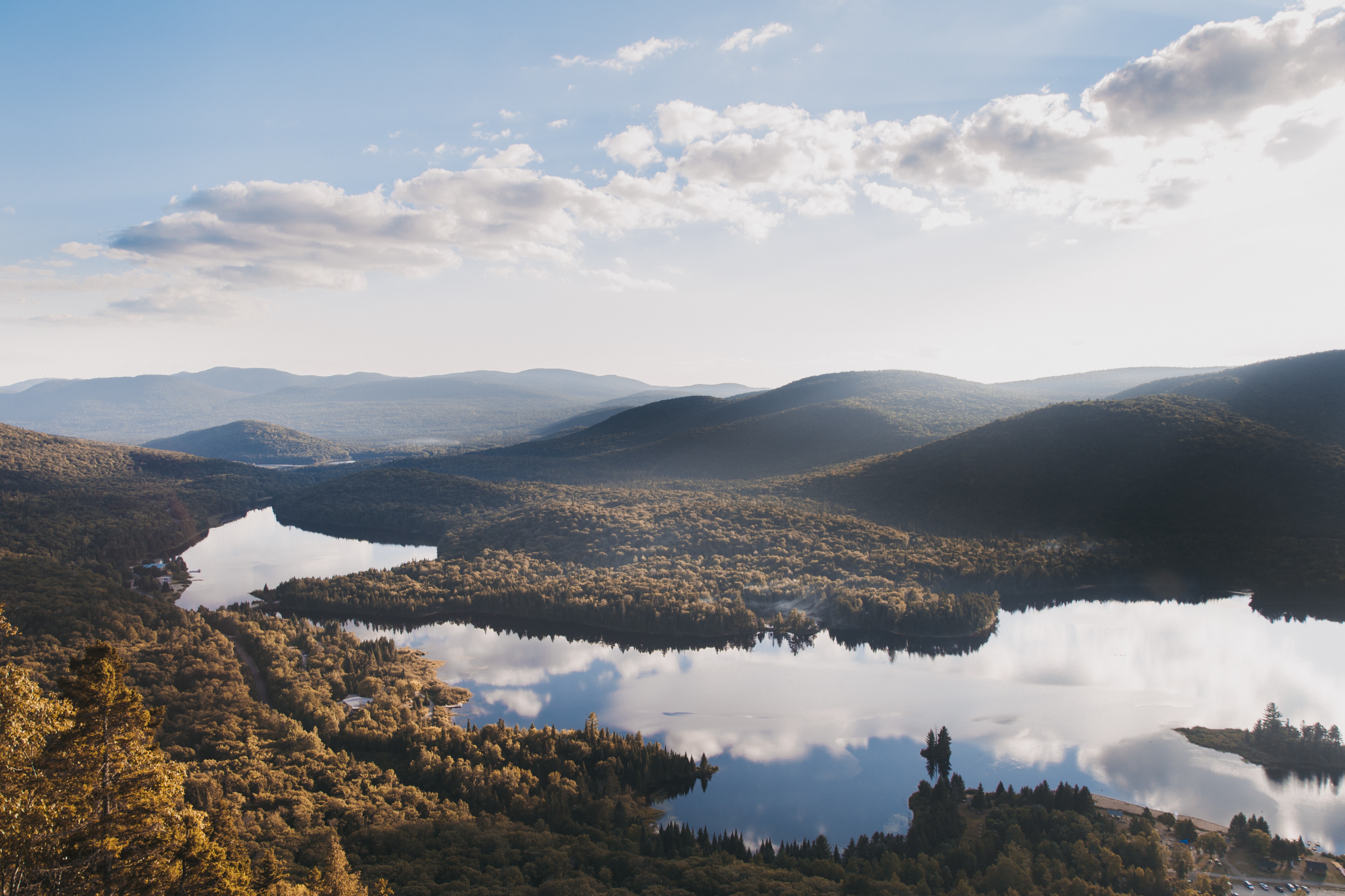 Vast clear water lakes mirror sky and clouds in heavily forested area, Mont Tremblant, in Quebec's Laurentians