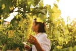A man holding a wine glass in the vineyard at the Inniskillin Winery