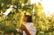 A man holding a wine glass in the vineyard at the Inniskillin Winery