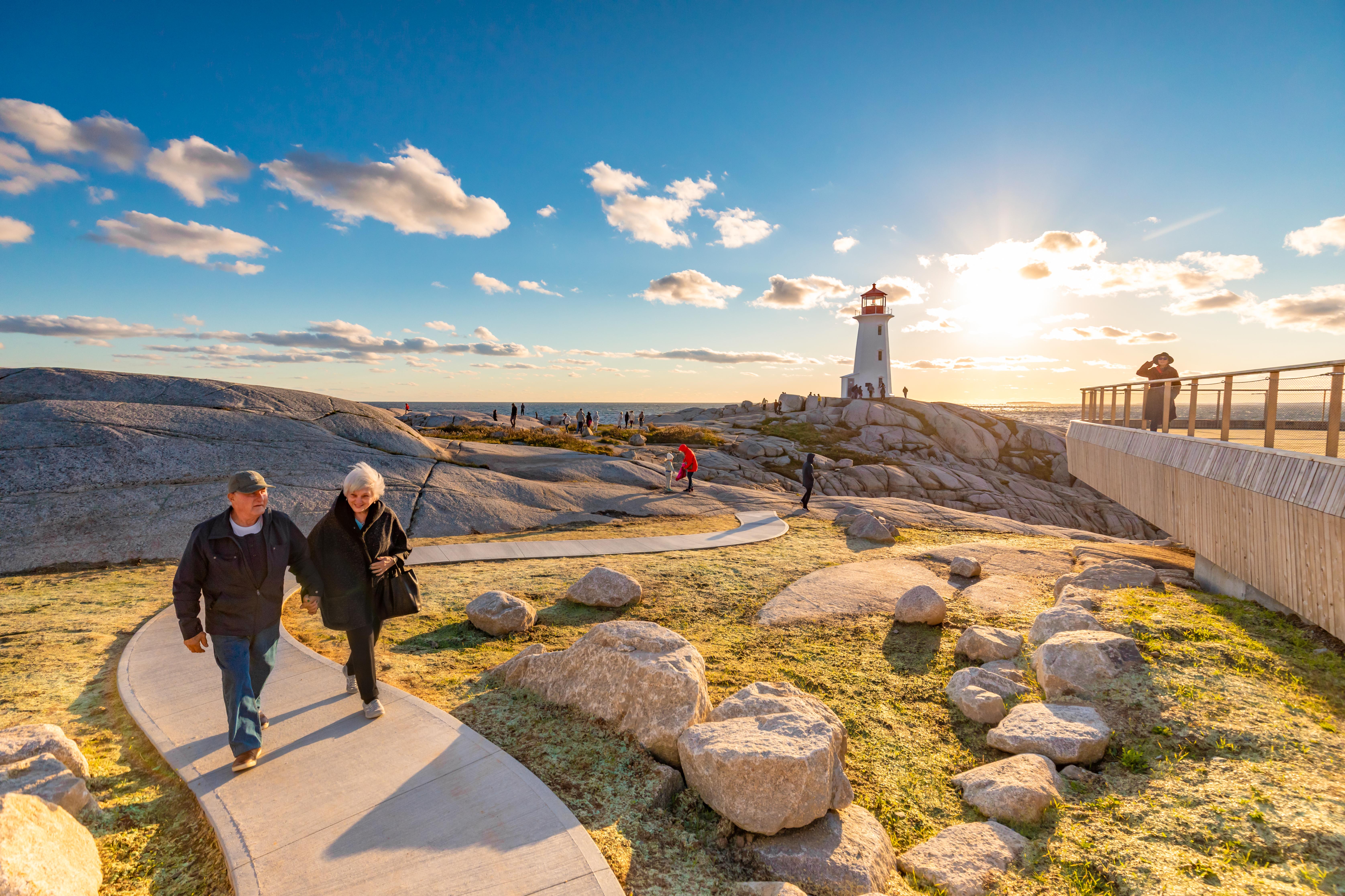 Senior couple holding hands depart from the South Shore of a sunny Peggy's Cove