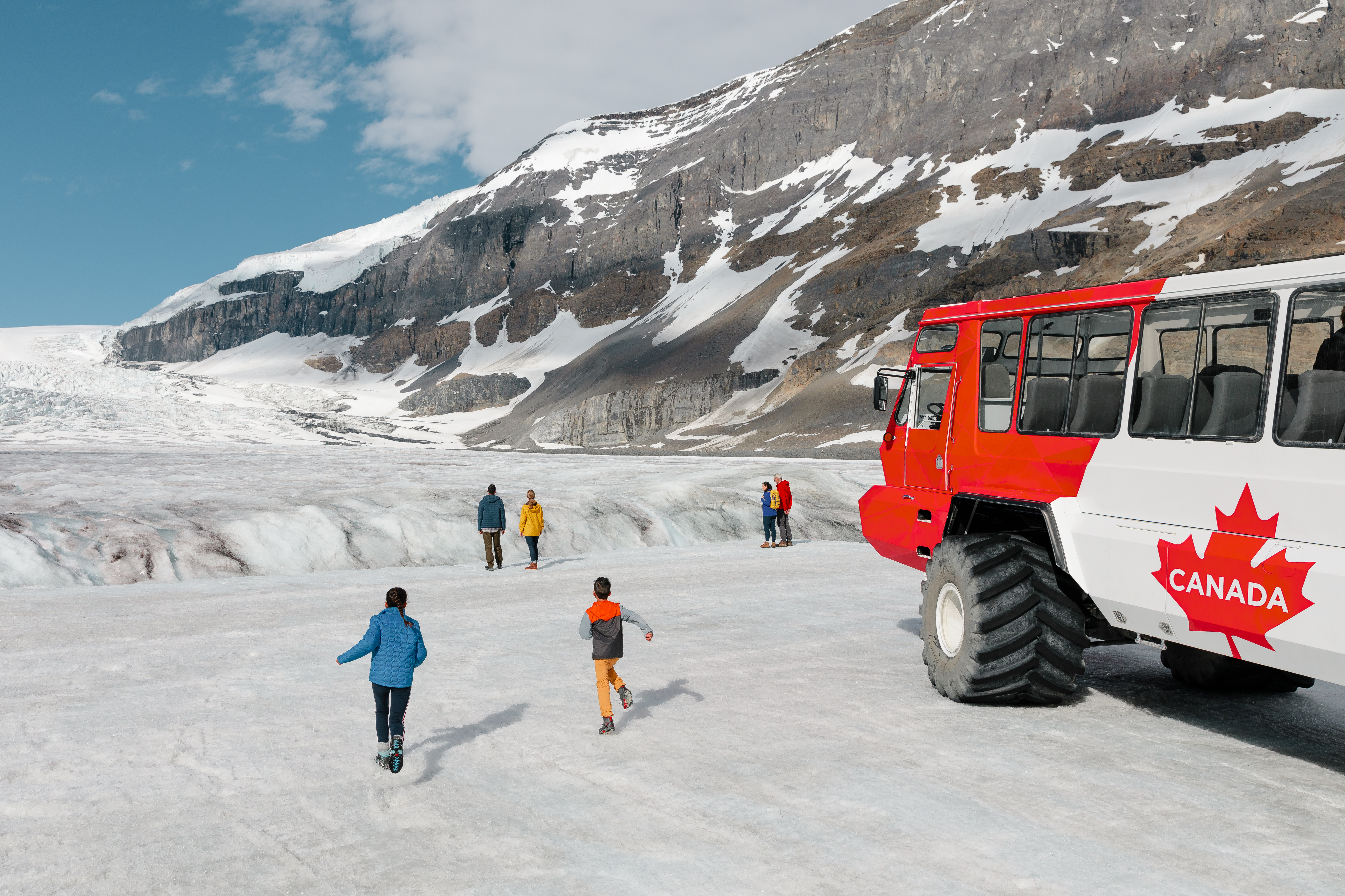 A group of people wander out on to the Athabasca glacier next to the Ice explorer.