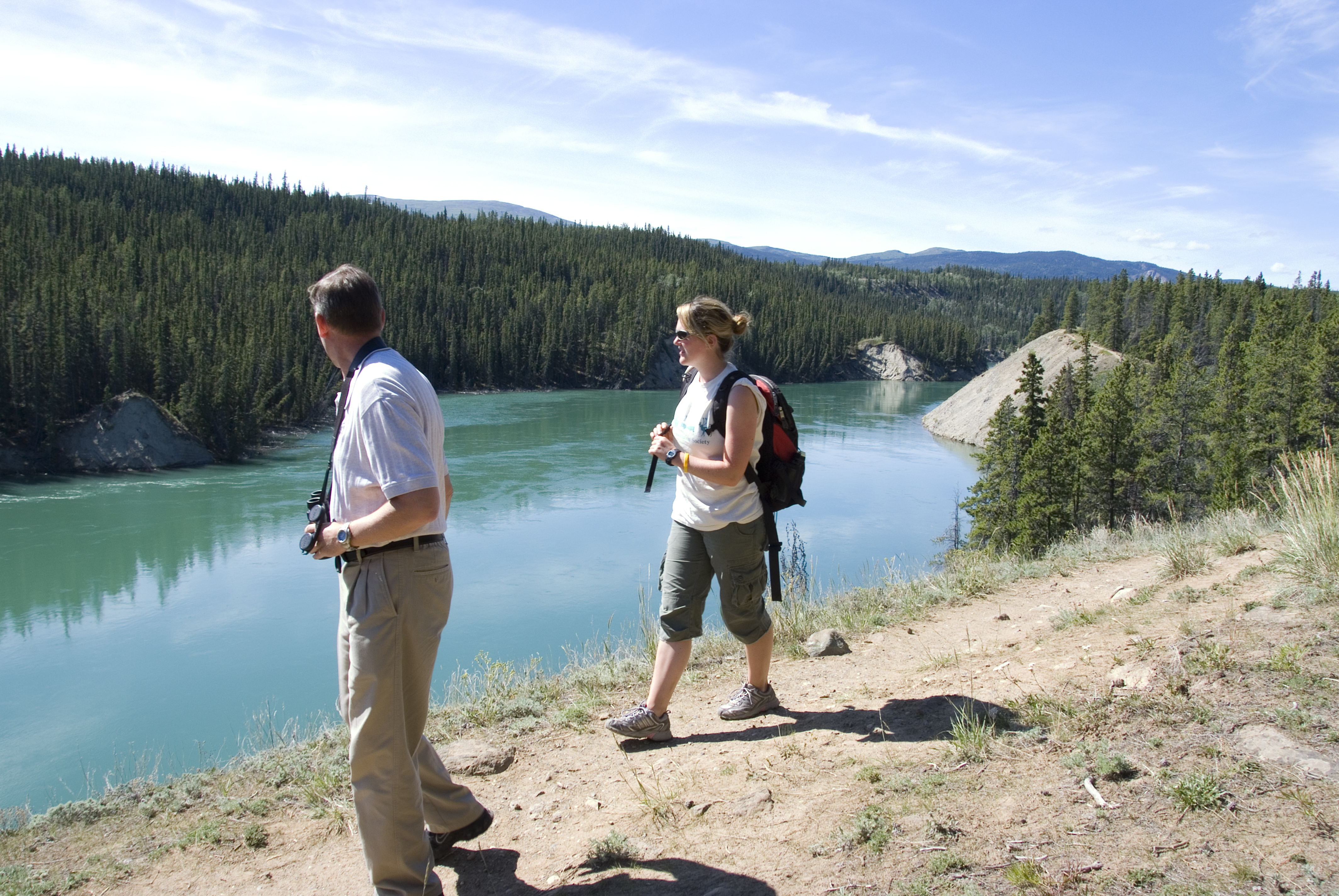 Visitors look at turquoise river in Yukon near Whitehorse