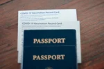 2 passport and vaccine record cards stacked on a table