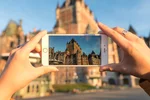 A person taking a picture of the Chateau Frontenac with the phone