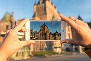 A person taking a picture of the Chateau Frontenac with the phone
