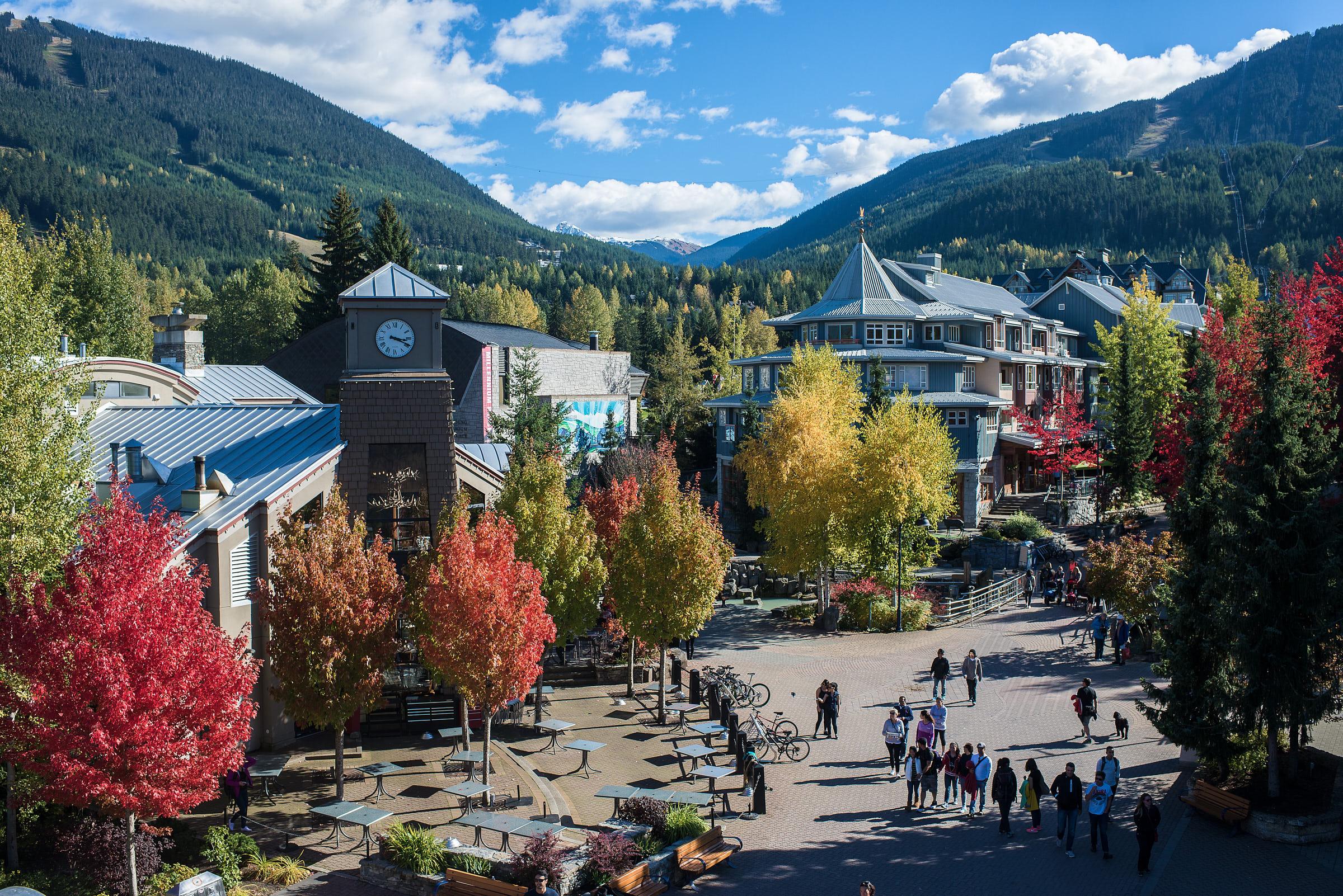 Whistler village pedestrian area with fall foliage and mountains behind