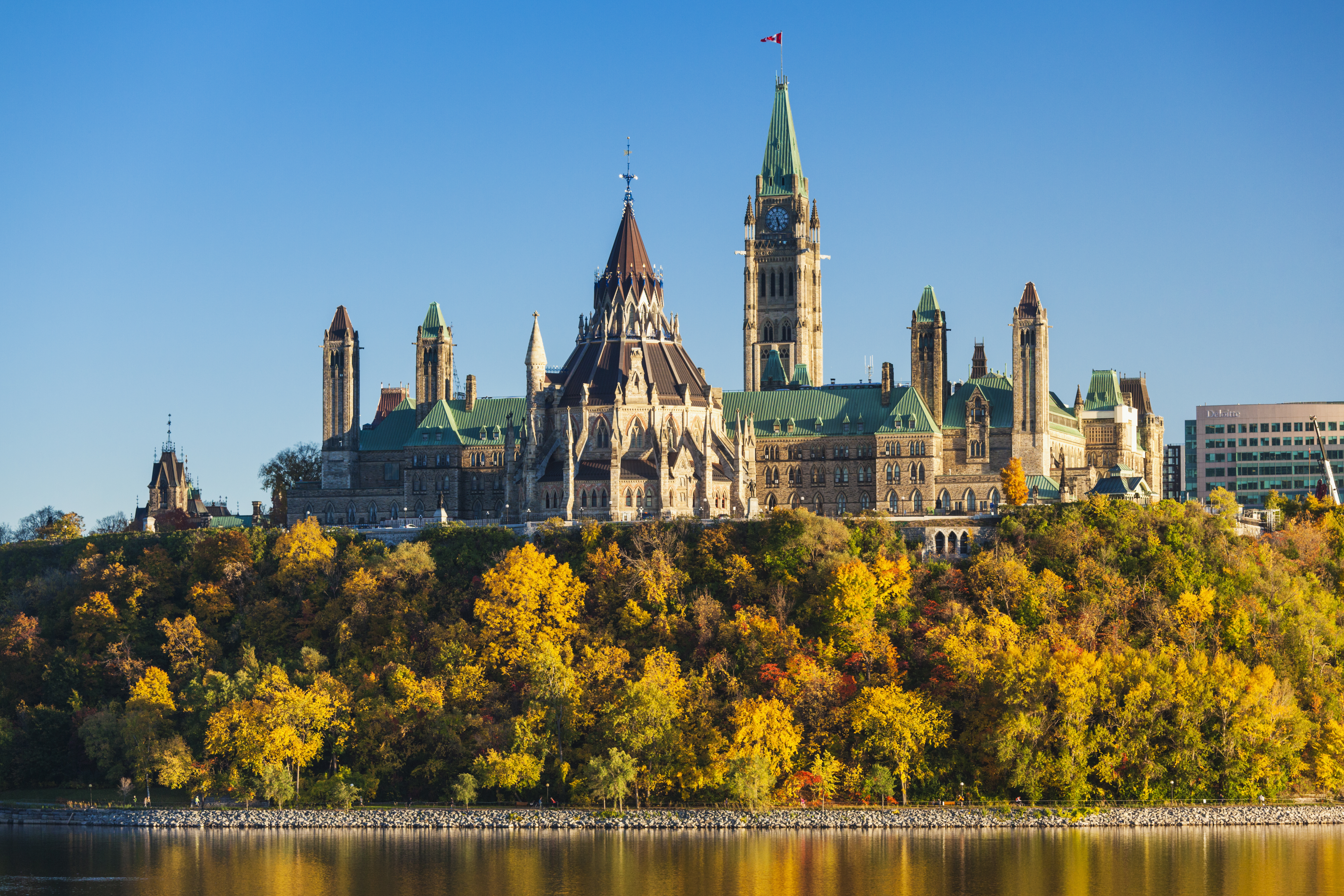 View of old building and fall foliage from across the river in Ottawa