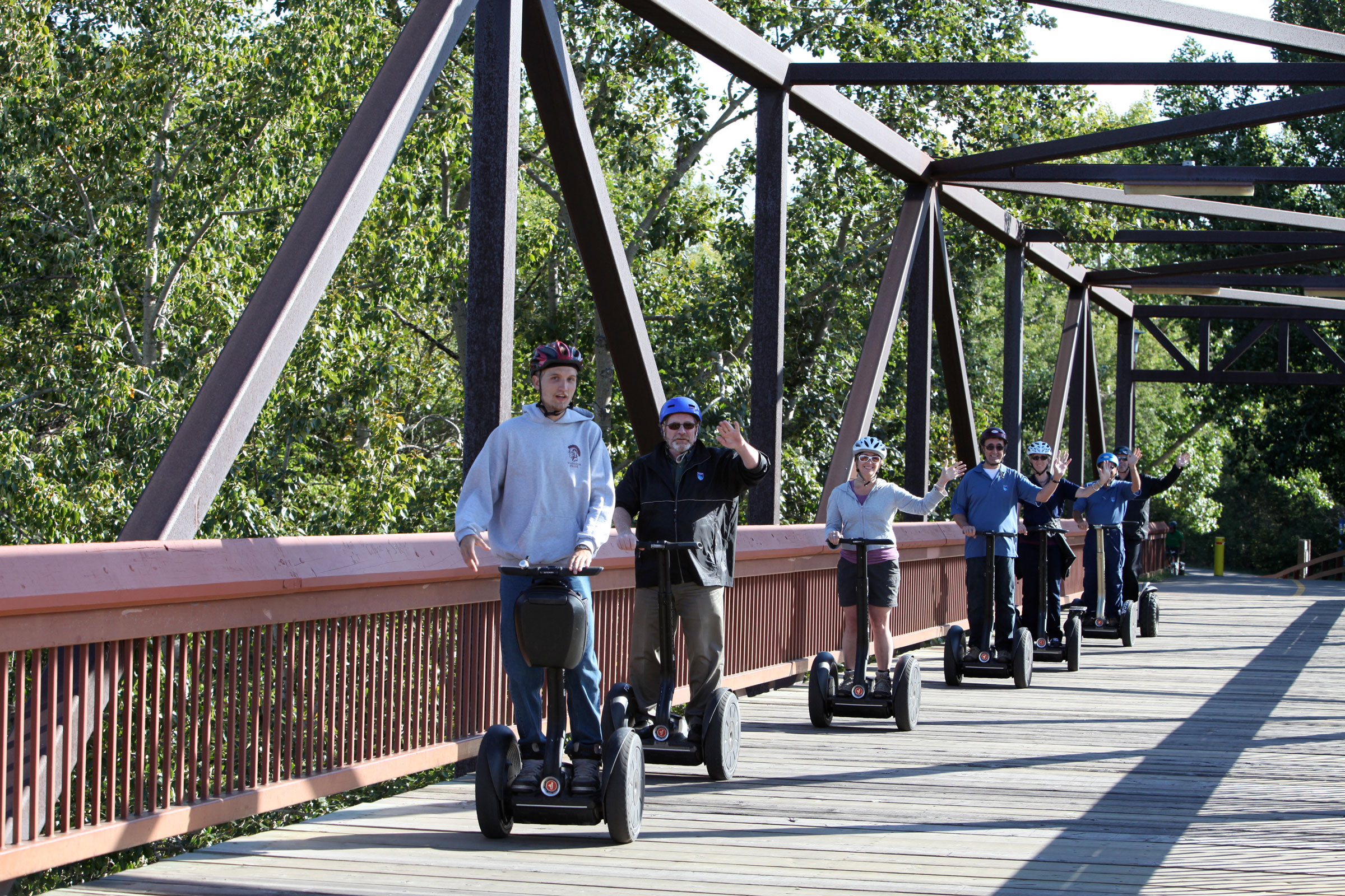 Group of people going over a bridge on segways in the Calgary River Valley