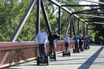 Group of people going over a bridge on segways in the Calgary River Valley